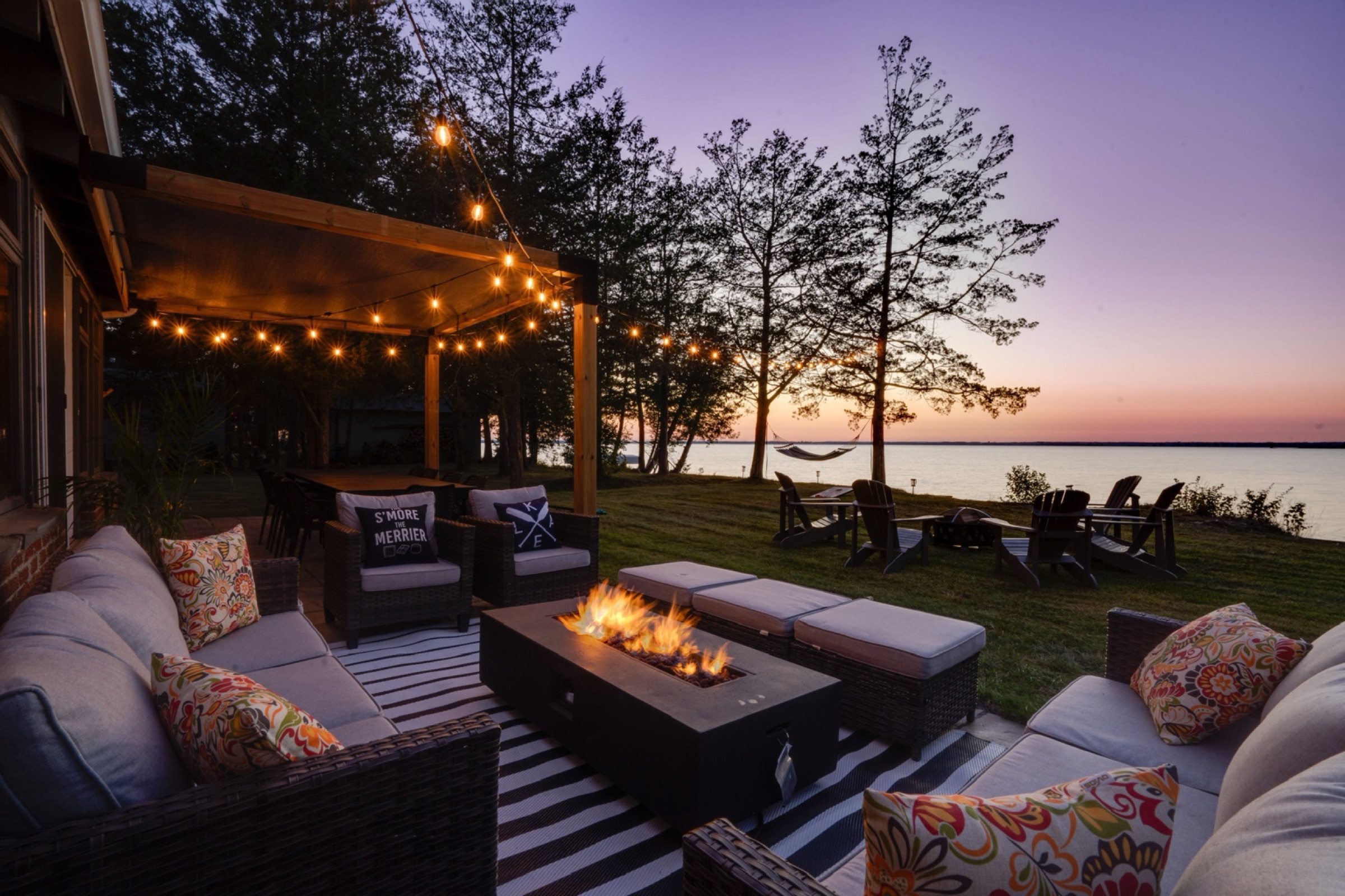 The County Casa waterfront patio and fire table at sunset