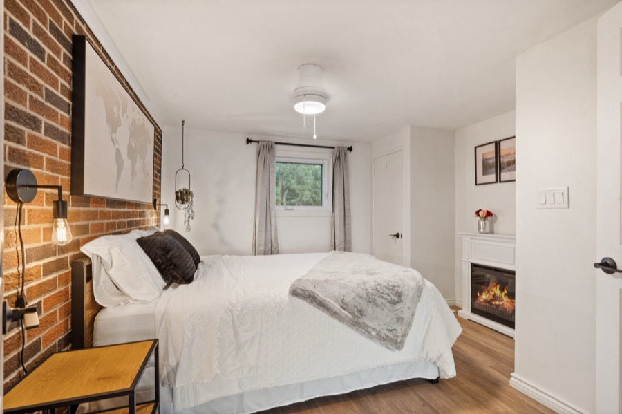 Brick-wall bedroom with an electric fireplace