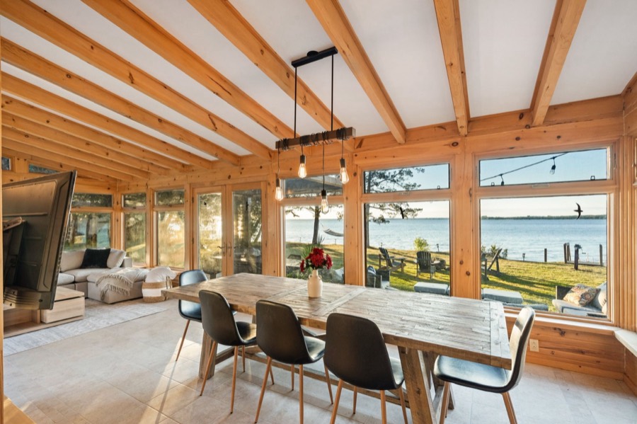 Harvest dining table beside large windows looking out over the bay