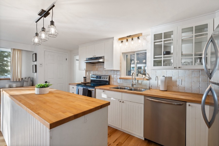 Kitchen counters with double sink, dishwasher and glass-front cabinets